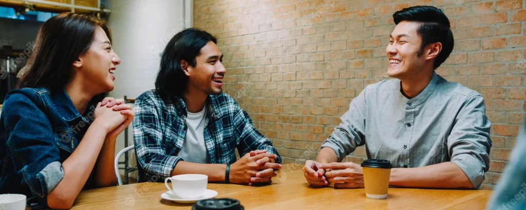 Three people having a conversation sitting at a table 