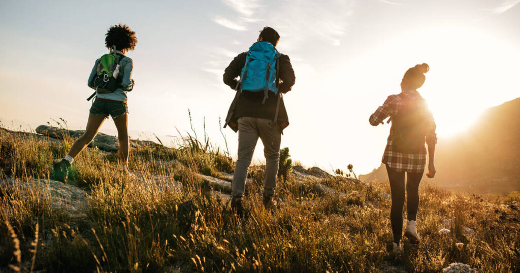 It shows three people hiking